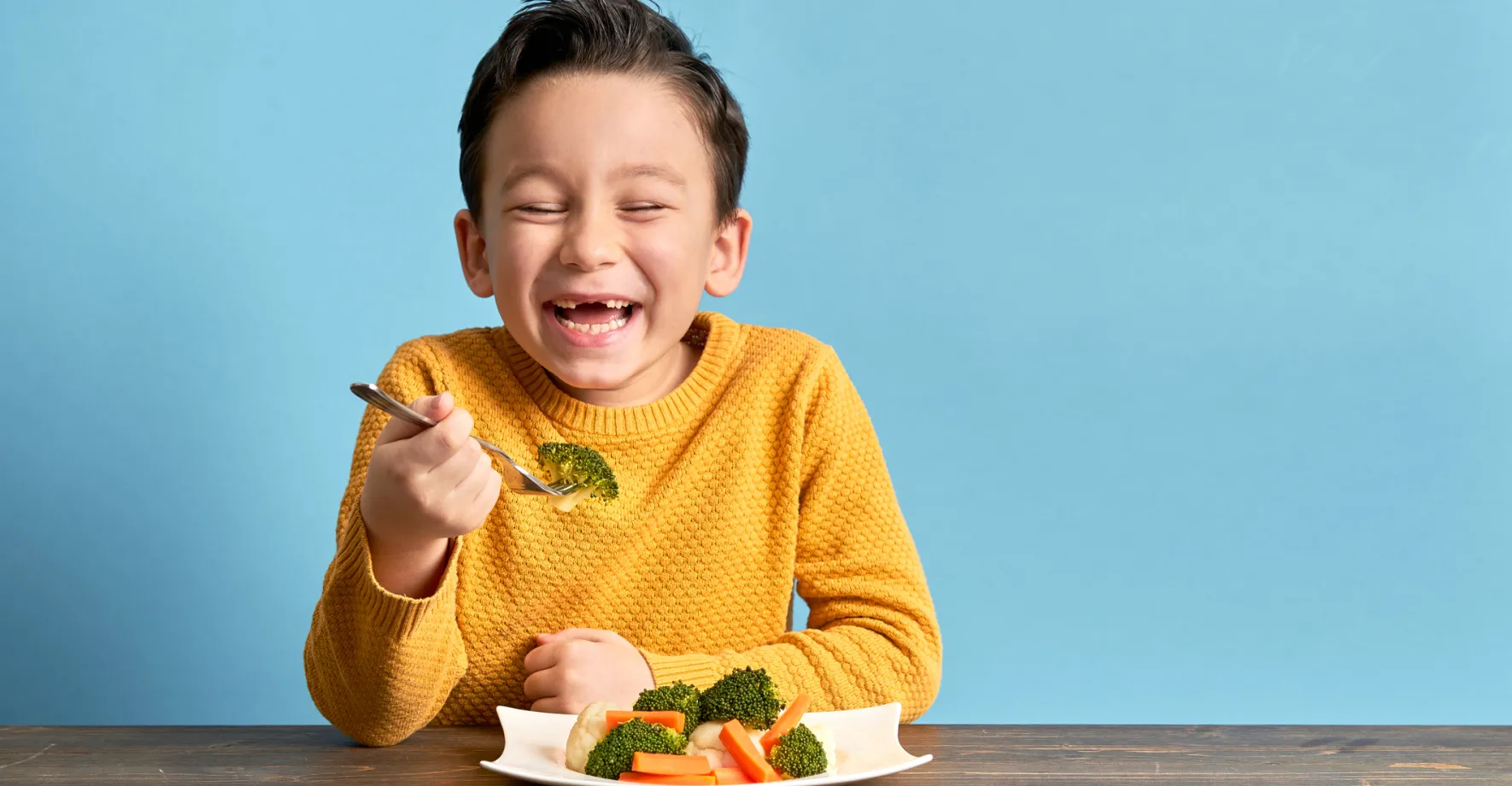 Smiling boy enjoying veggies