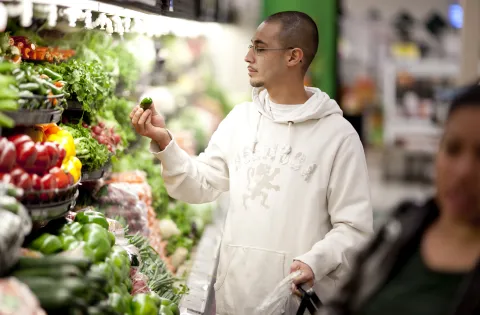 Man looking at pepper in produce isle 