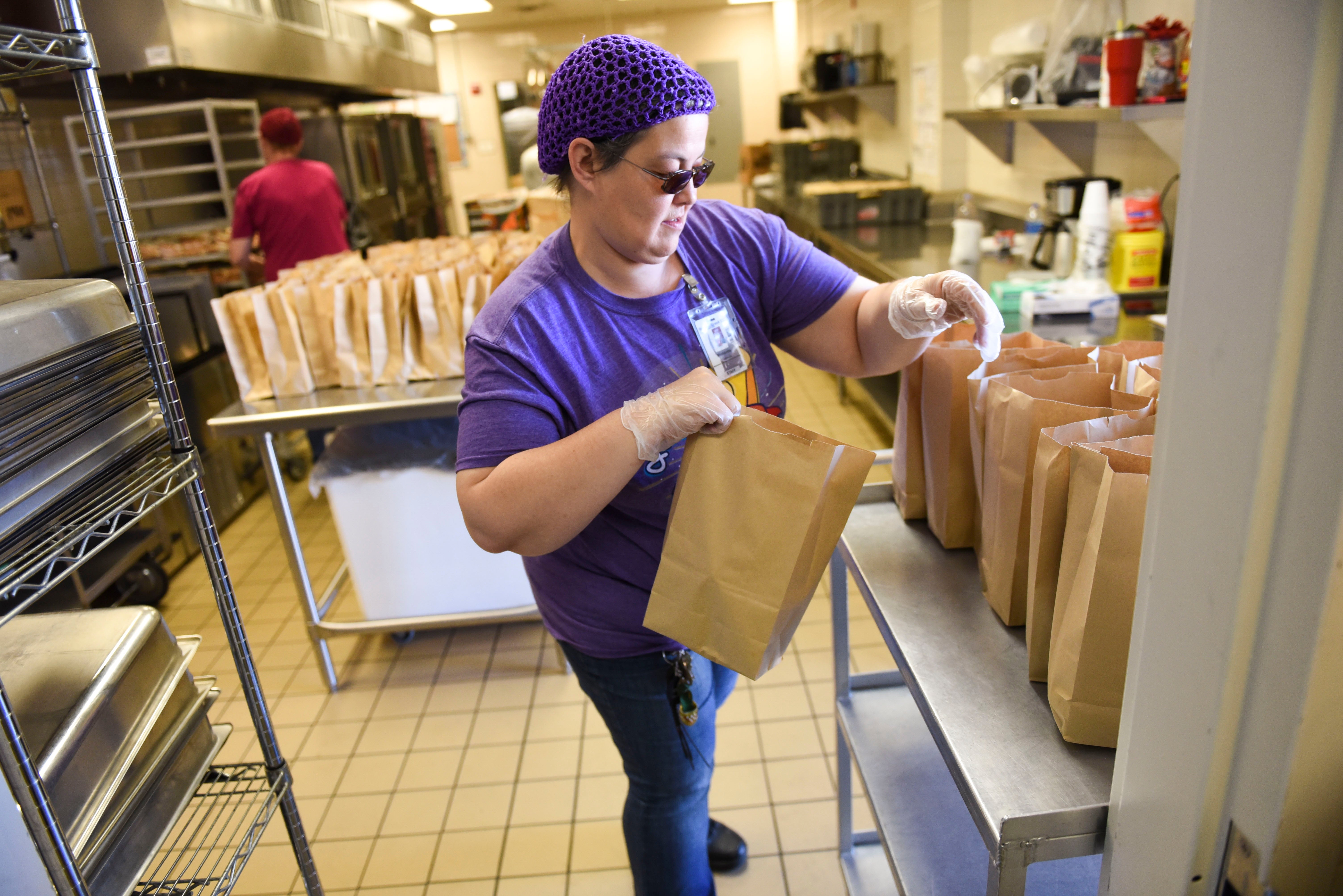 A volunteer helps with food distribution