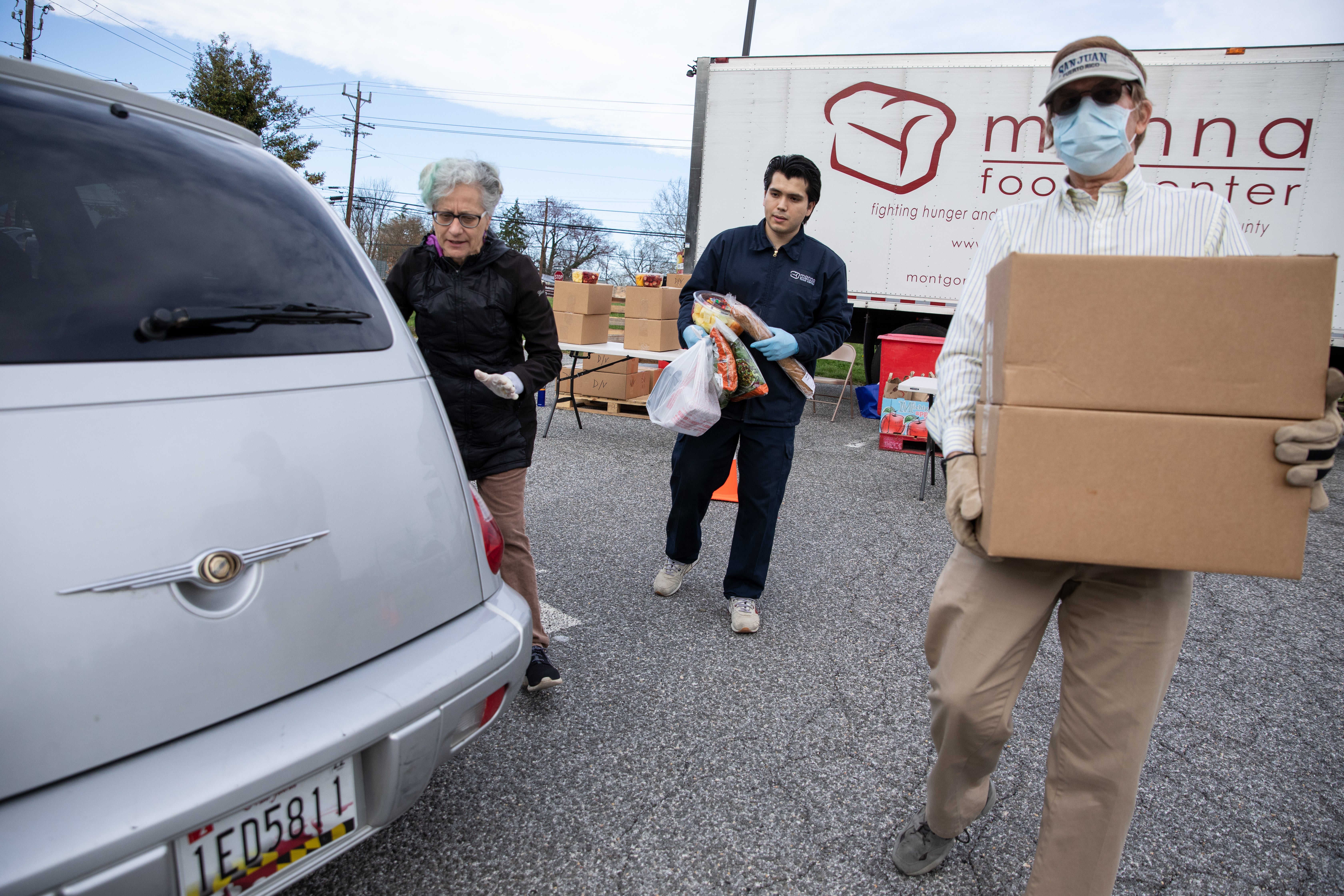Volunteers load food into cars at a meals site in Maryland.