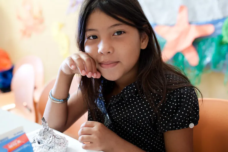 A child sits at school, eating.