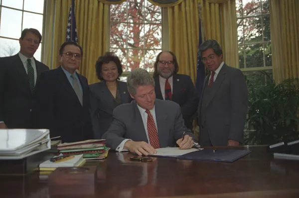 Patsy Mink behind president Clinton signing a paper