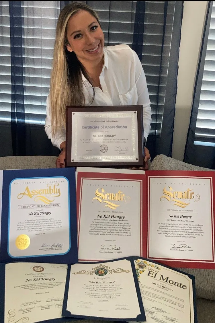 Andrea Cuellar holding recognitions 