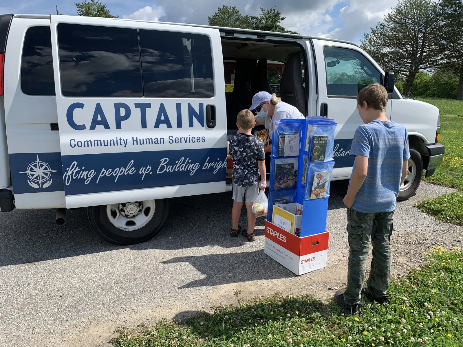 Woman handing out food to kids