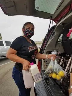 Woman with mask delivering food.