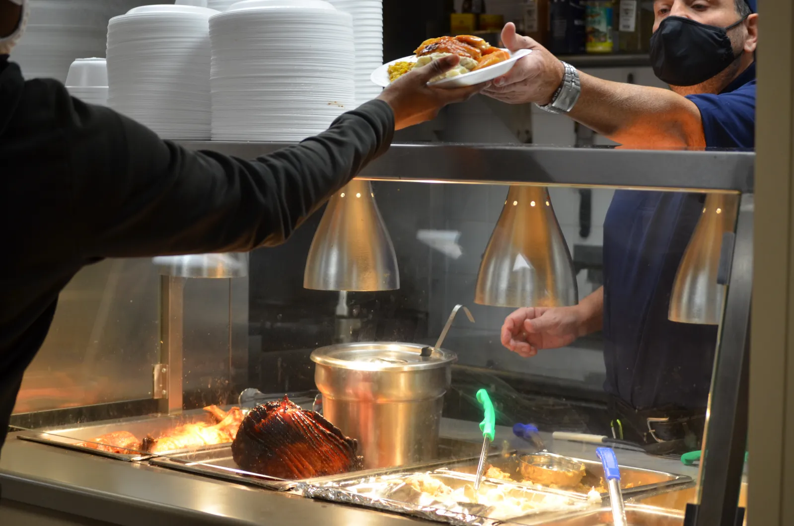 Man passing food to young adult