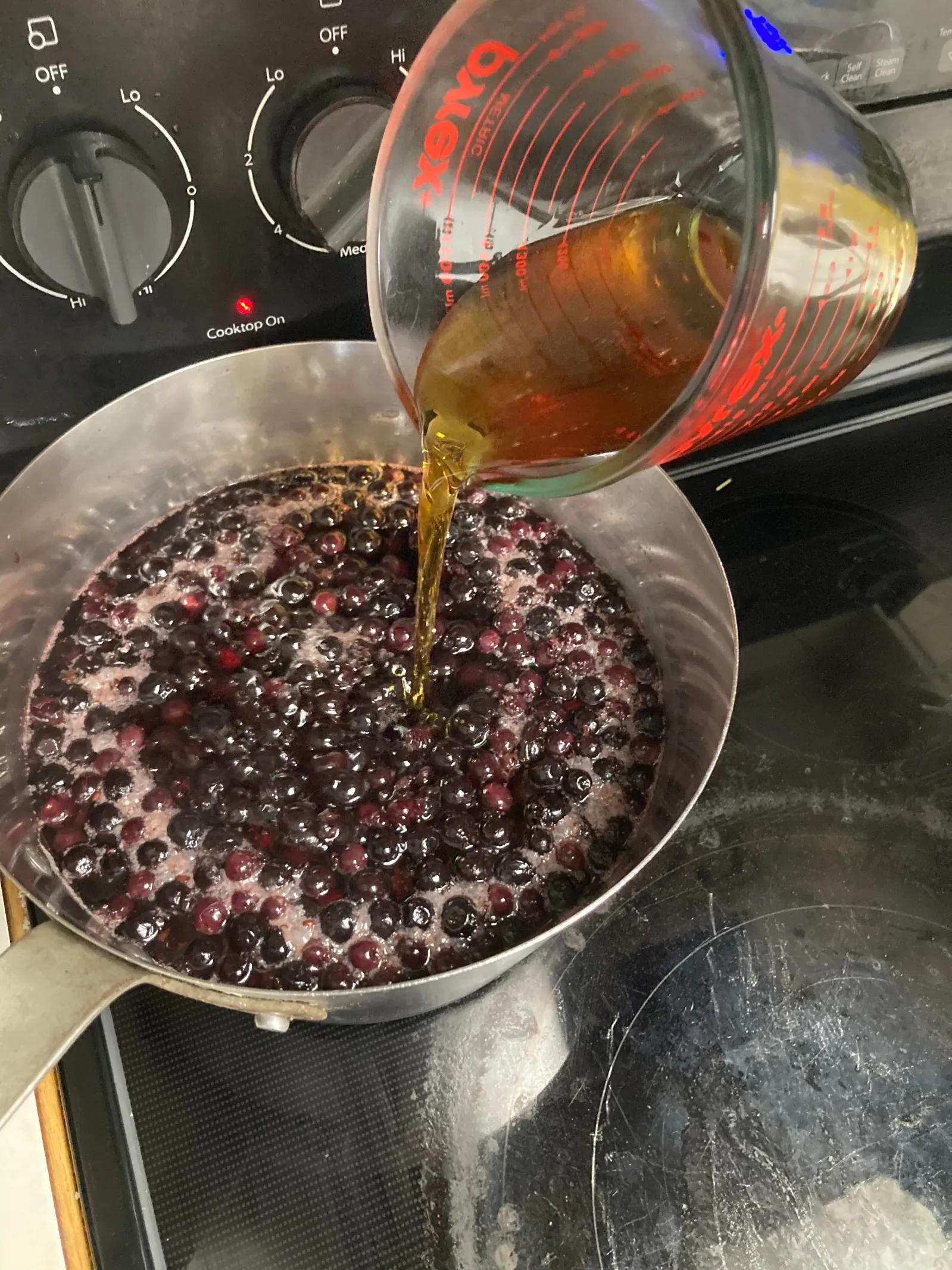 Adding liquid to a pot full of berries