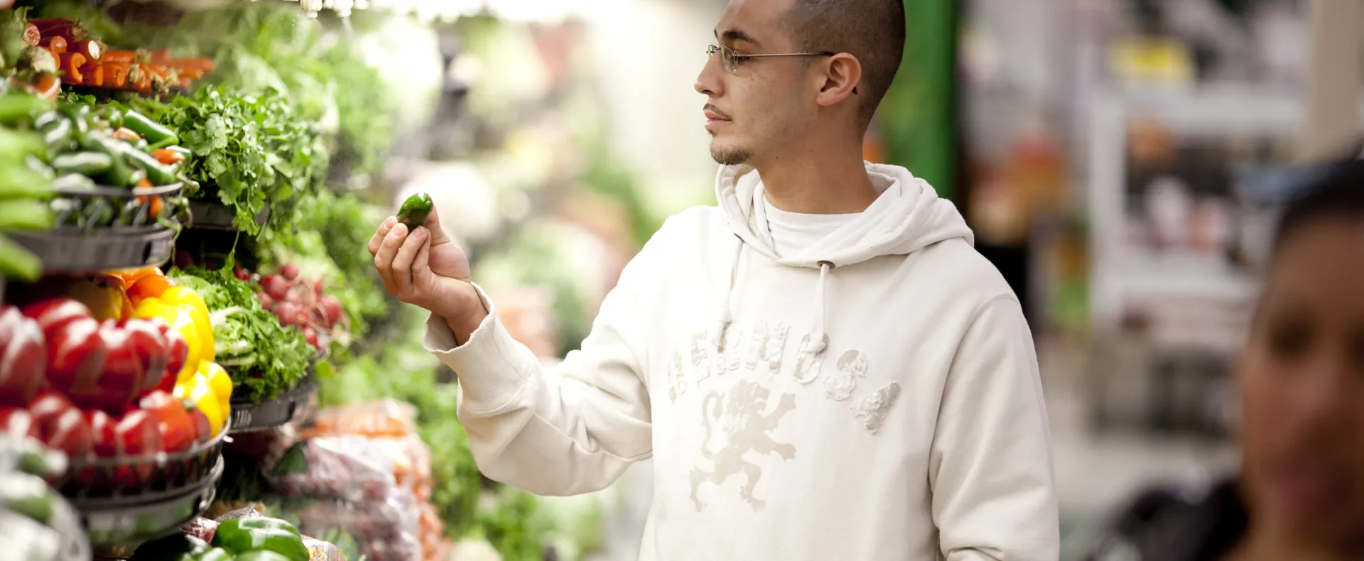 Man looking at pepper in produce isle 