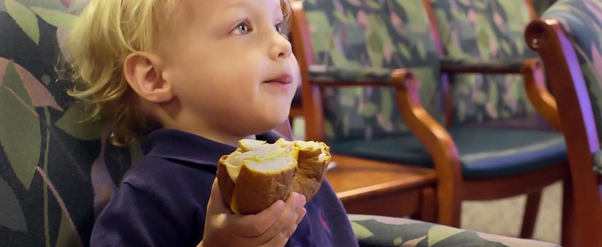 Kid eating croissantwich