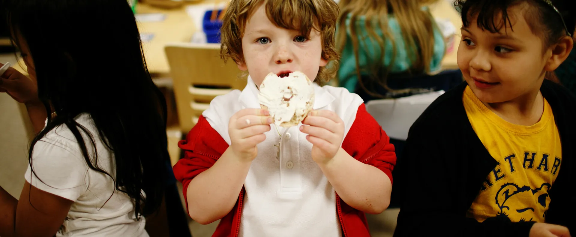 A little boy eating breakfast at school 