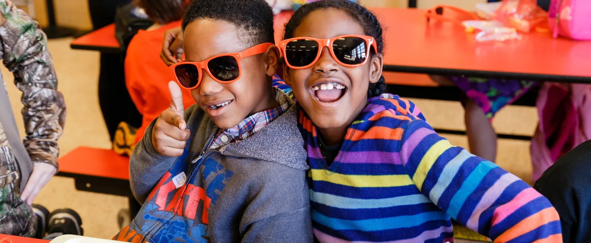 Happy kids wearing No Kid Hungry sunglasses