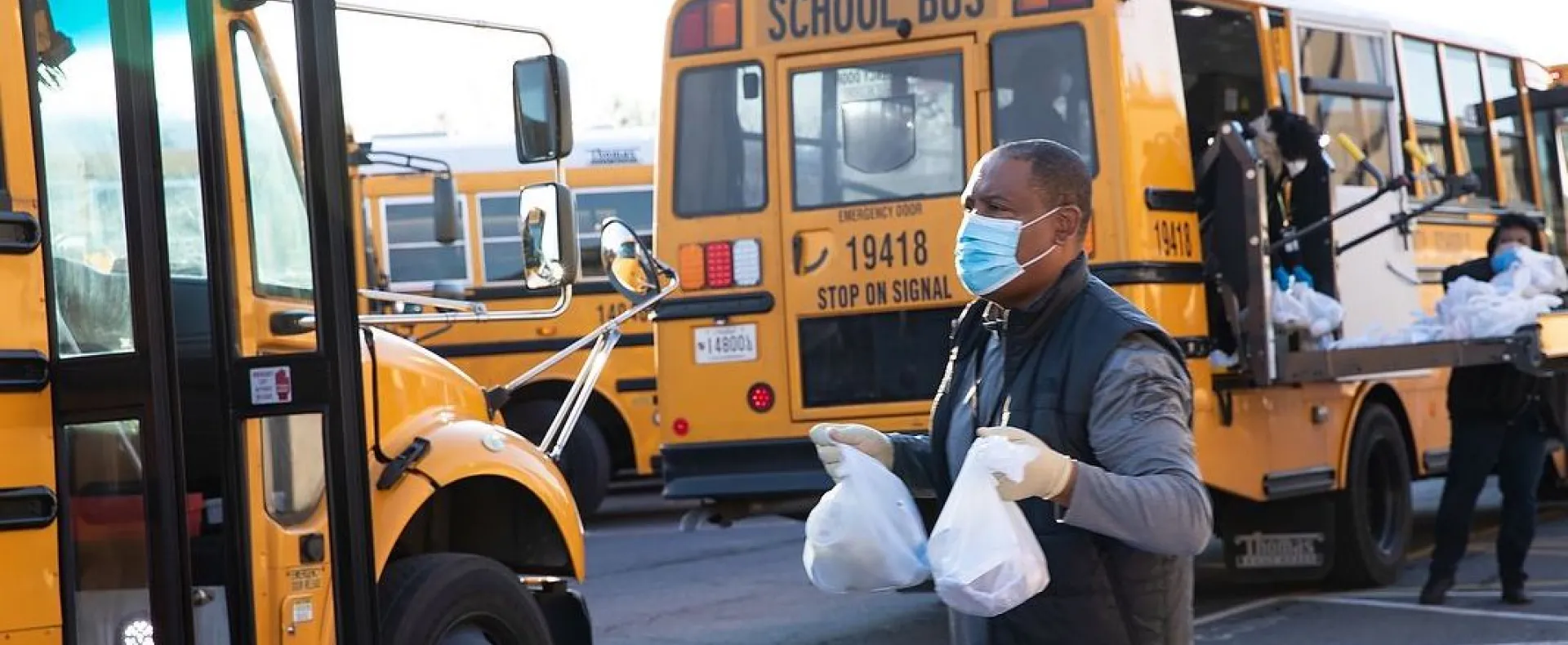 man carrying food to bus during coronavirus