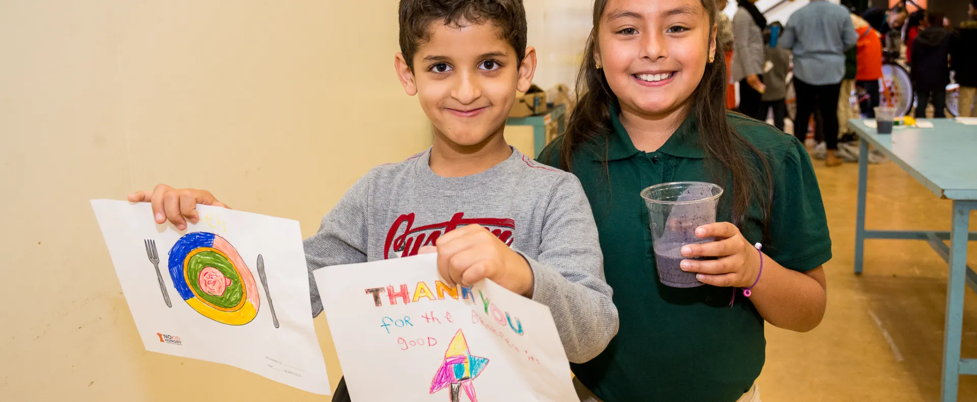 Boy and Girl. Boy holding thank you note and girl with cup of water