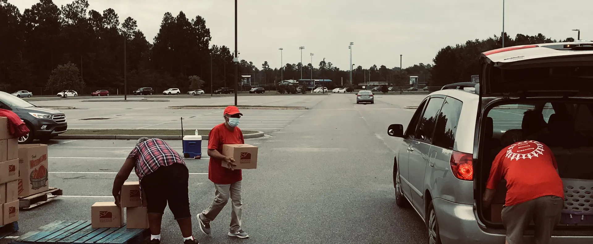 People putting boxes in a car