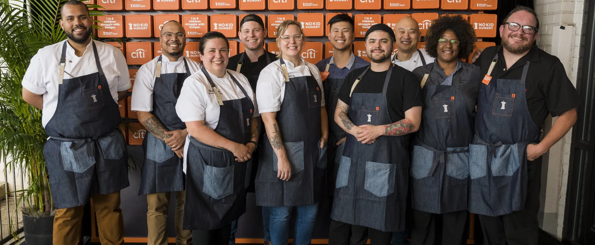 A group of prominent chefs pose for a group picture at a No Kid Hungry event