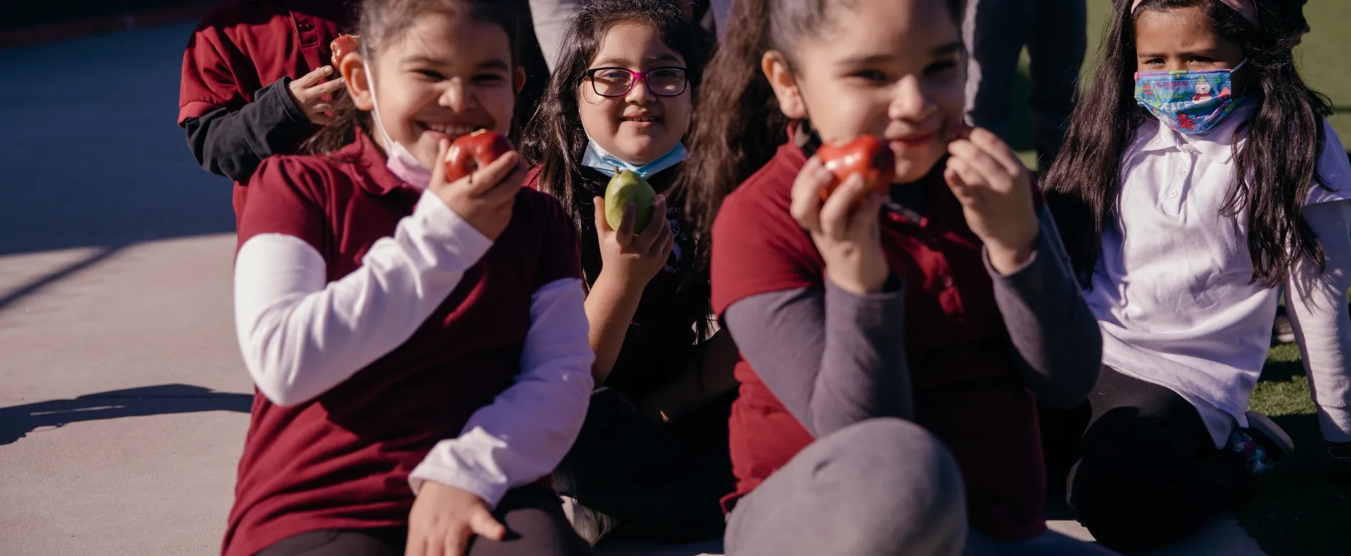 Kids eating apples and smiling