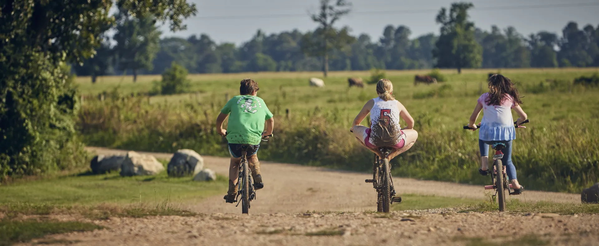 3 white kids on bikes rural