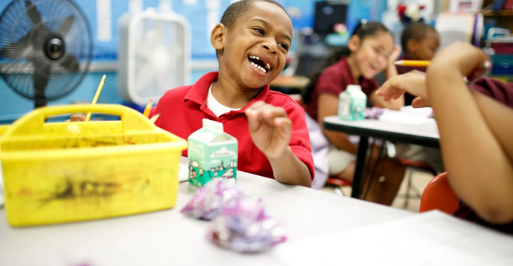 A little boy really digging breakfast in the classroom