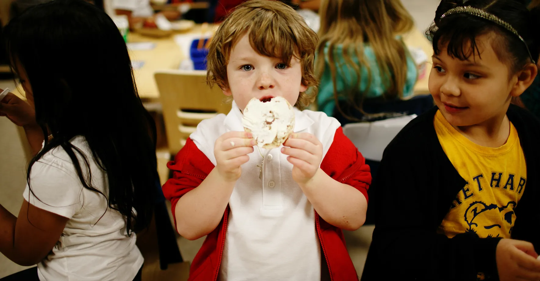 A little boy eating breakfast at school 