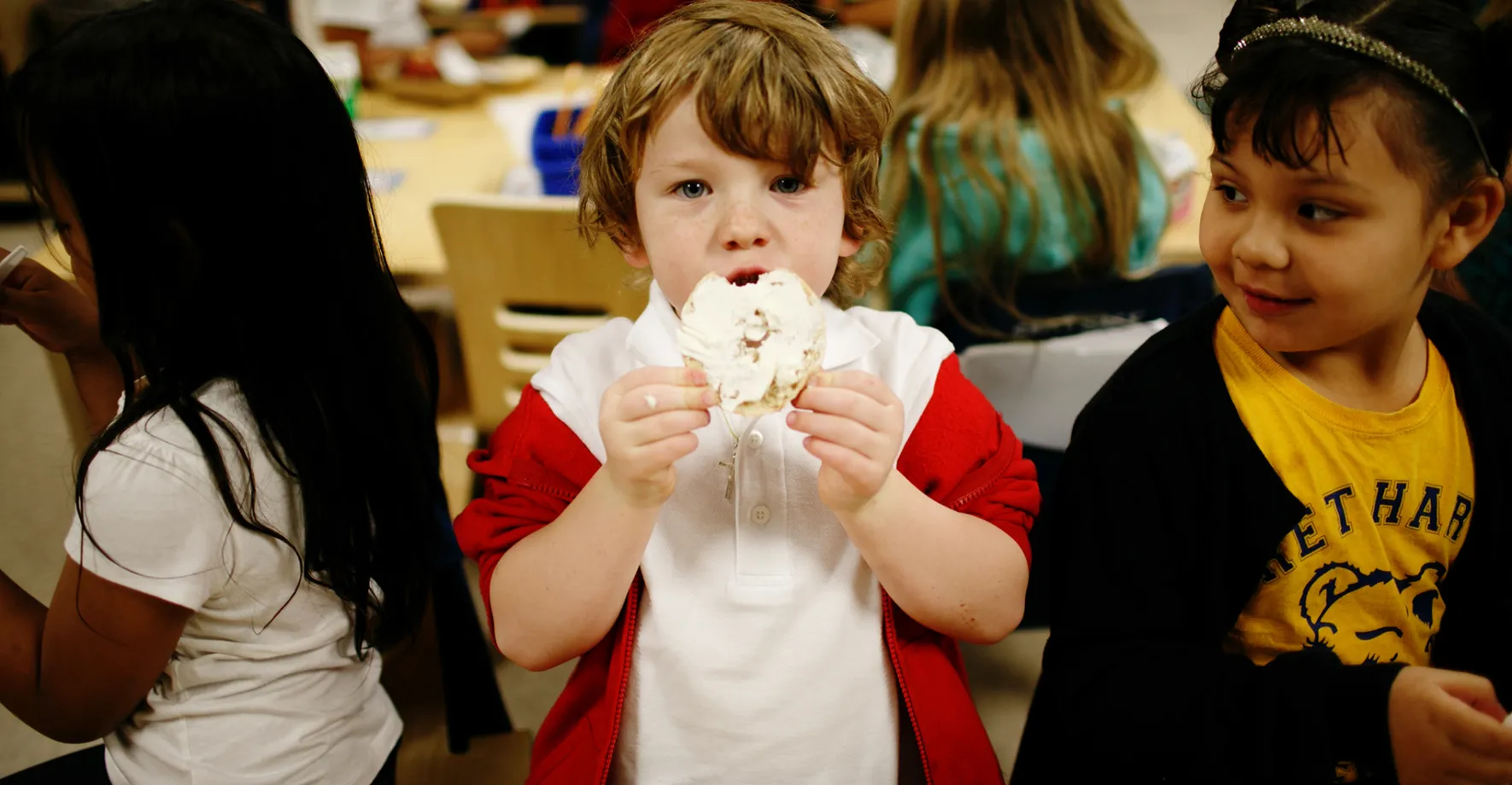 A little boy eating breakfast at school
