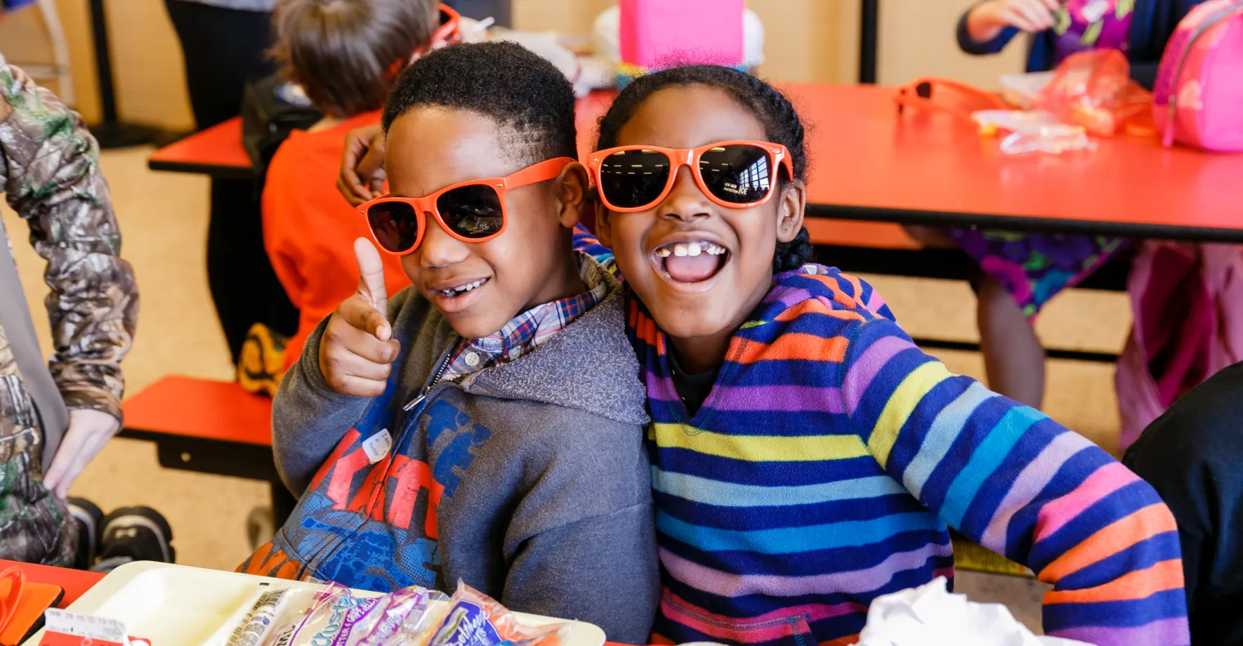 Happy kids wearing No Kid Hungry sunglasses