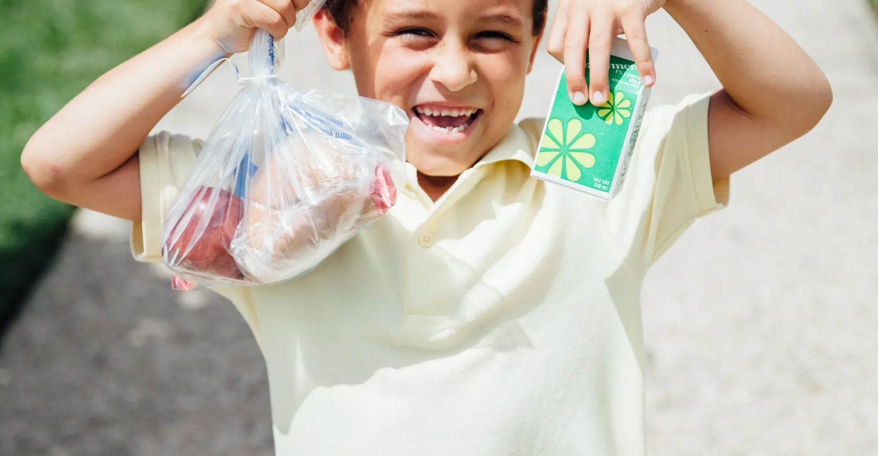 Happy boy holding bags of food