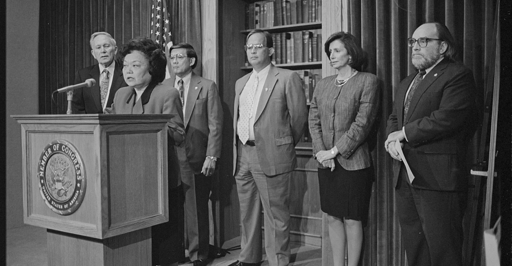 Patsy Mink Congresswoman talking in a podium with people behind
