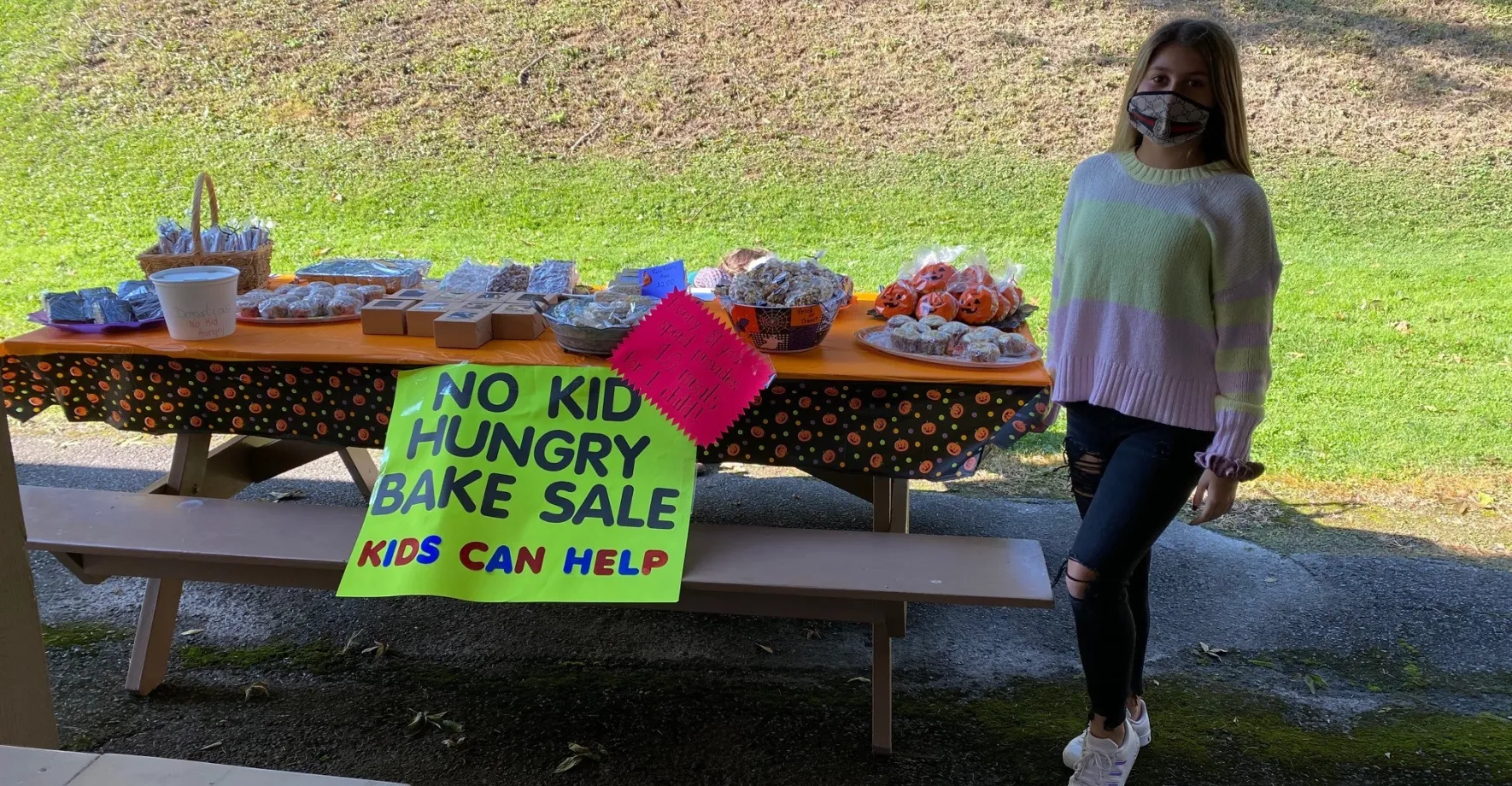 Girl wearing mask at bake sale charity event