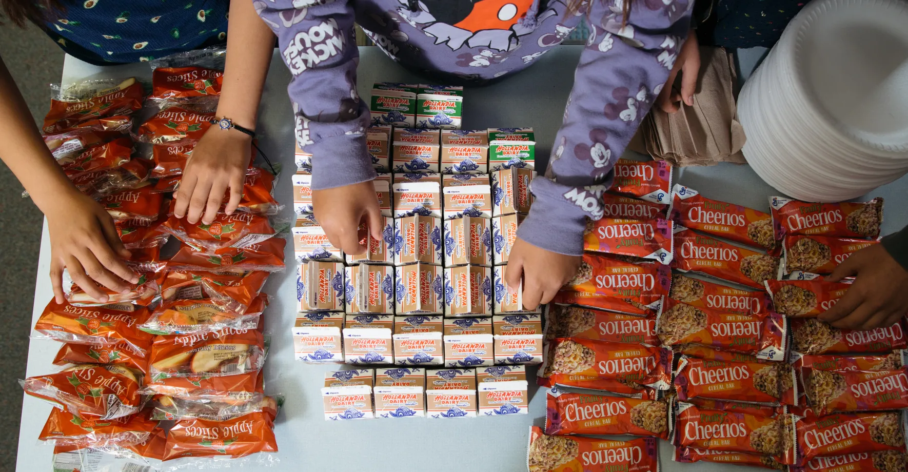 Bird's eye view of breakfast items and kids hands