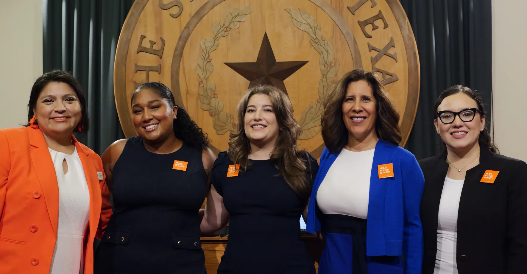 5 Latino women in front of Texas banner