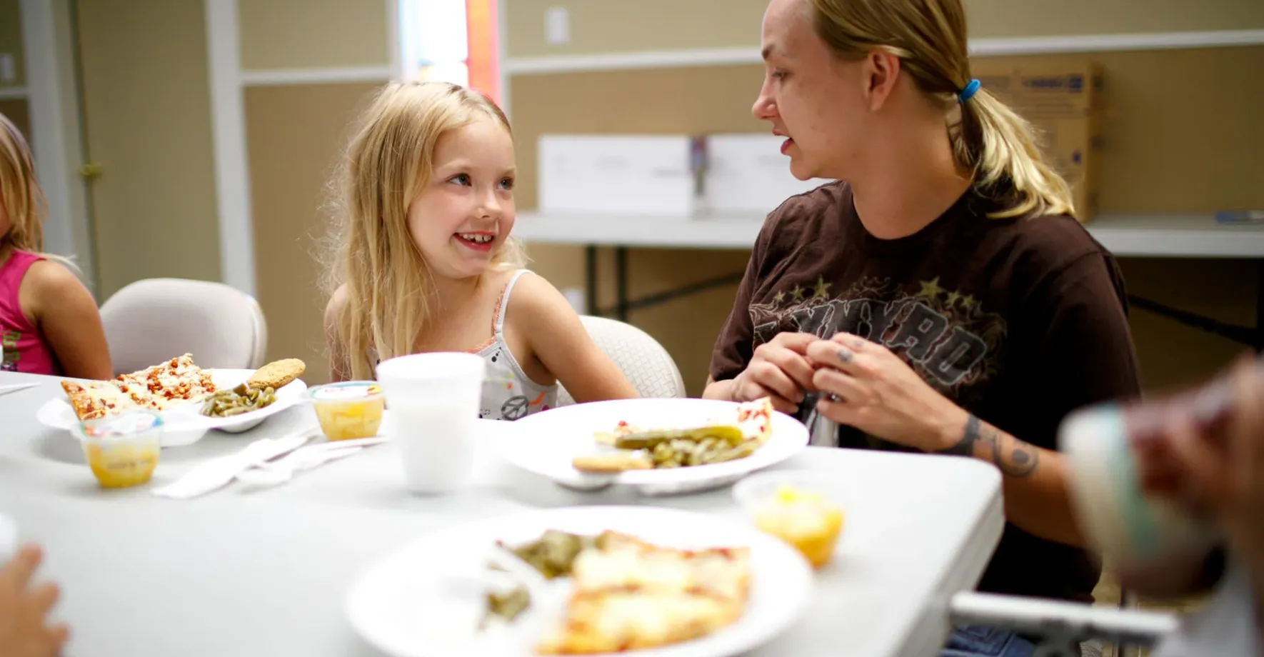 Child eating lunch with mother