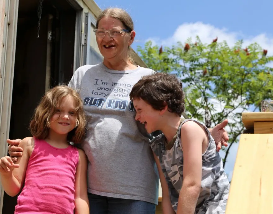 Sue, Patrick and Scarlett outside of their home