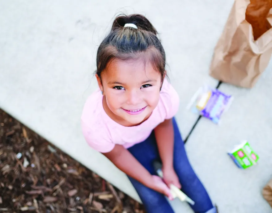 Little girl enjoying a free summer meal.