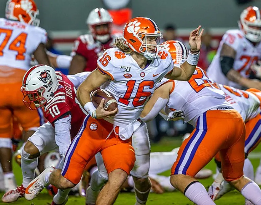 Football Players avoiding being tackle. Wearing orange and white