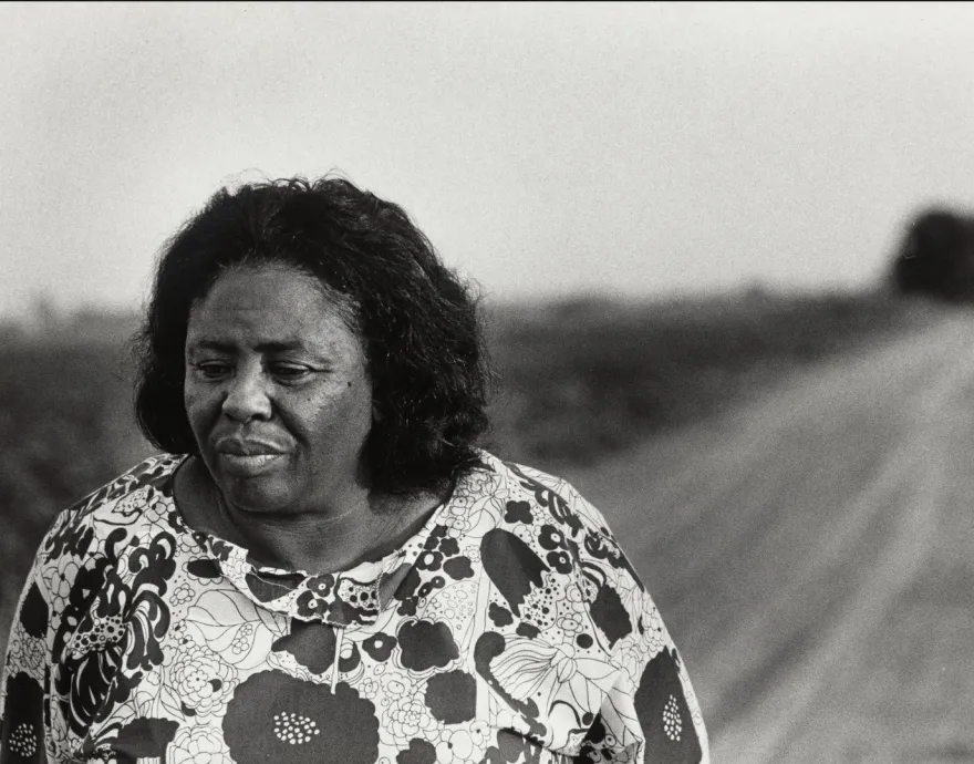 Black woman walking on a field. Black and white picture