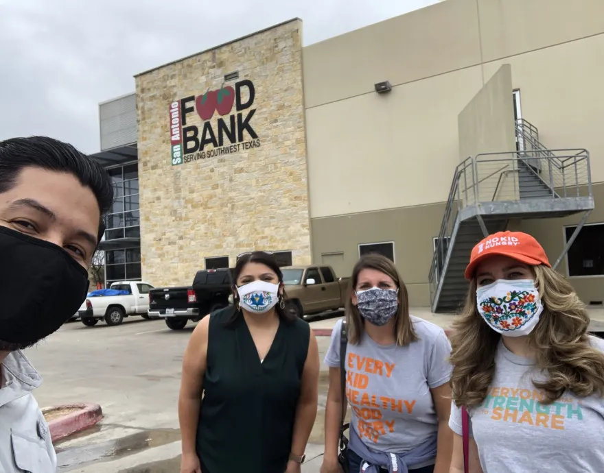 4 masked people in front of food bank