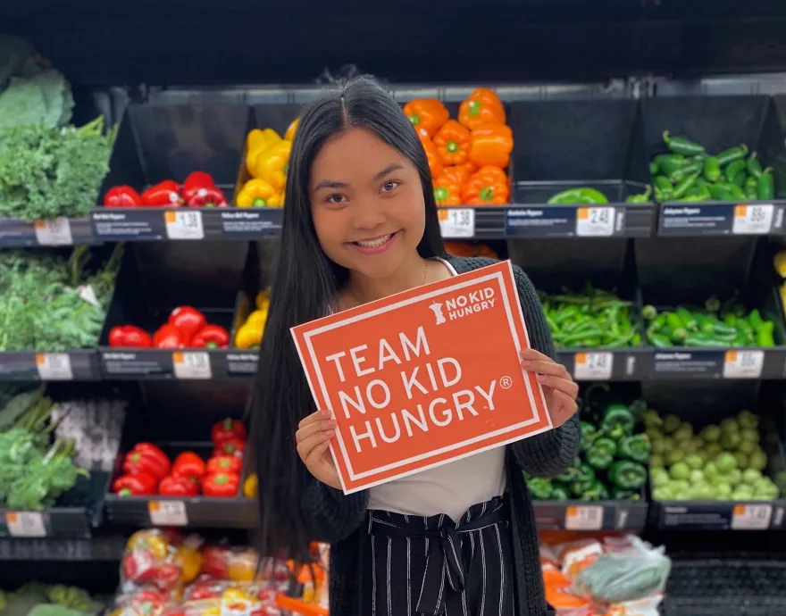 Youth Ambassador in front of fresh veggies