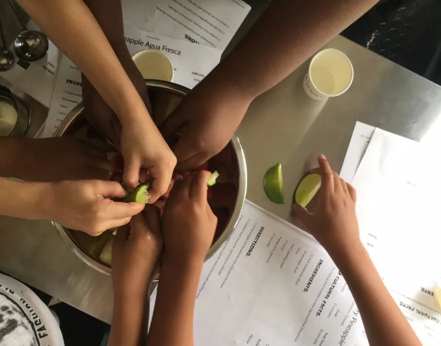 Hands of kids coming together to cook