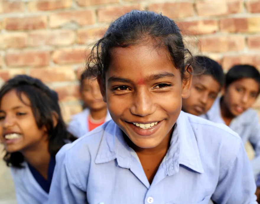Group of children in blue collared shirts, smiling