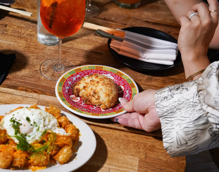 Hand reaching for biscuit on plate