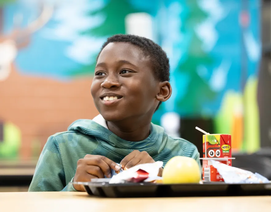 Picture of child with lunch and callout to sign up for the quarterly newsletter