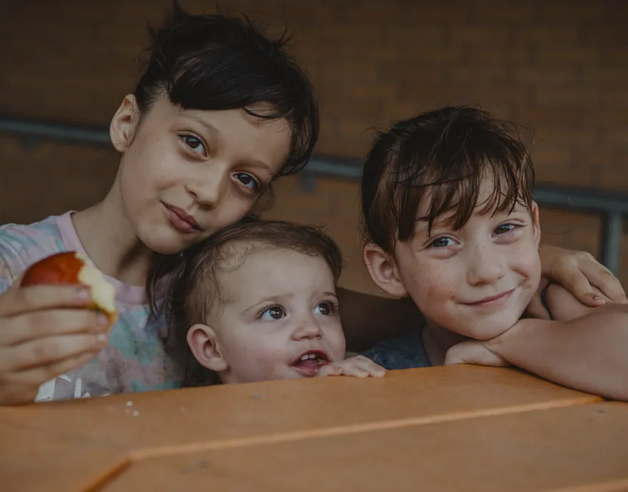 Smiling kids sitting at a picnic table