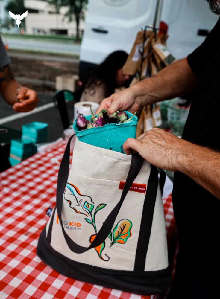 Bagging groceries into No Kid Hungry tote bag