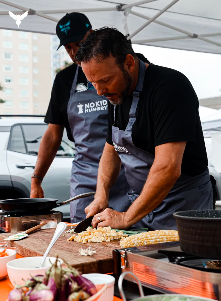 Chef cutting corn off cob in live demonstration