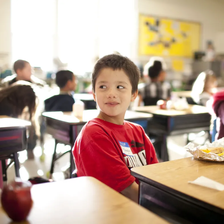 Boy sitting at desk with food