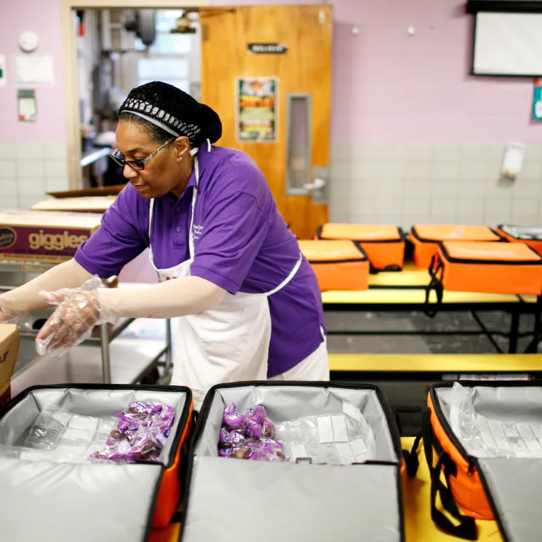 A cafeteria worker preparing breakfast