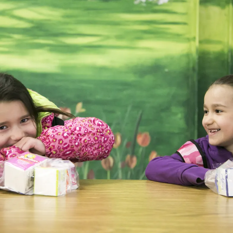 two girls eating school breakfast