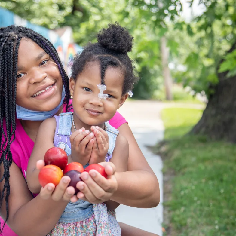 Black Mother and Daughter with Masks and Apples in Michigan