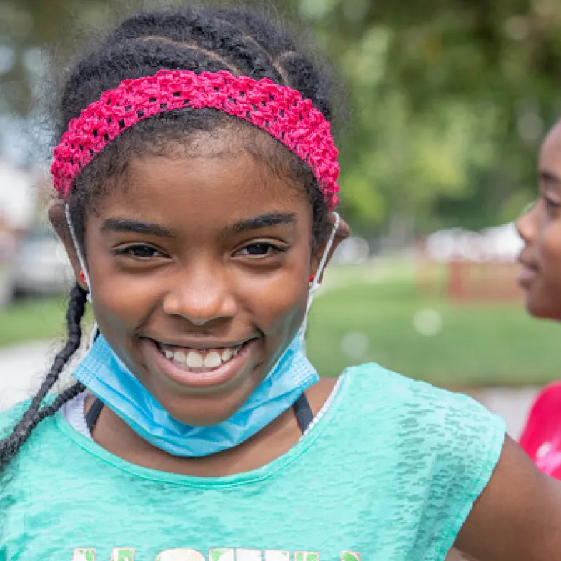 Girl smiling with mask under chin