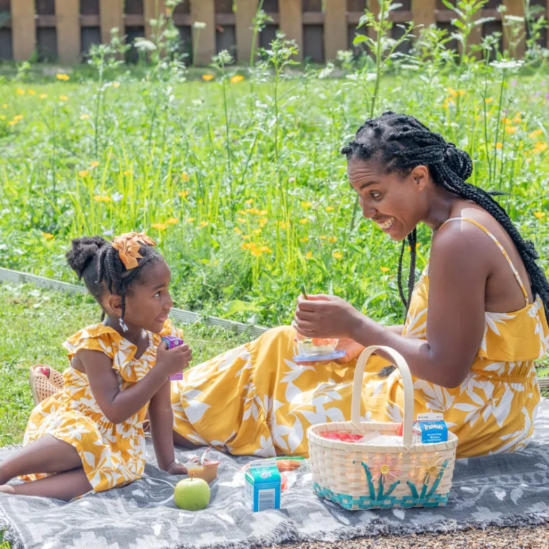 Mom and daughter having a picnic both wearing yellow dresses